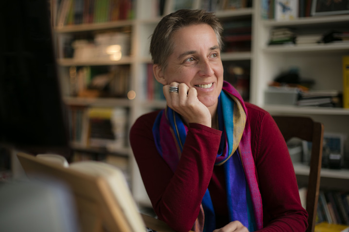 Maike Dörries am Schreibtisch in ihrem Arbeitszimmer, im Hintergund ein Bücherregal